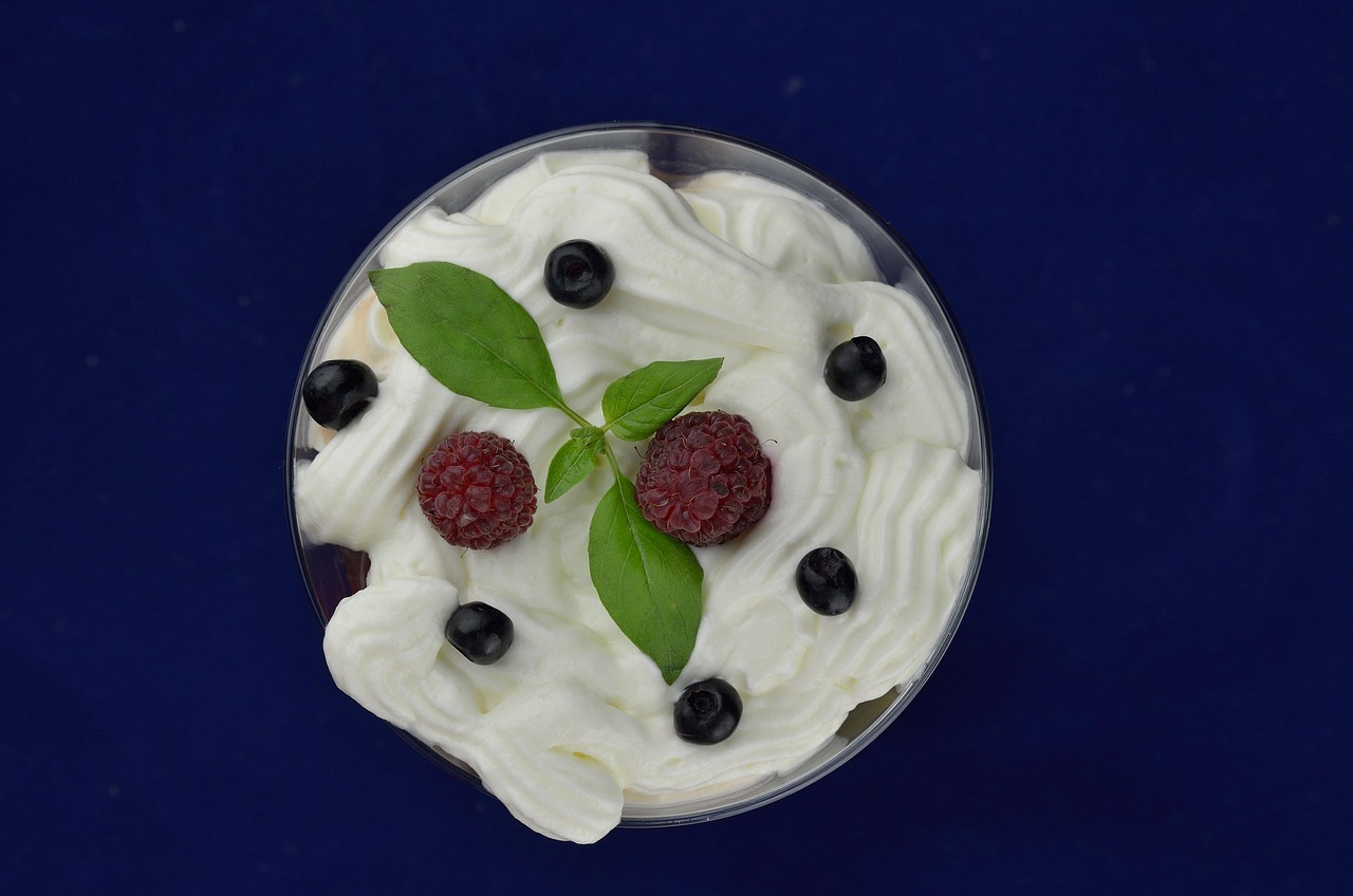 Ciotola con crema chantilly montata, decorata con fragole fresche.
