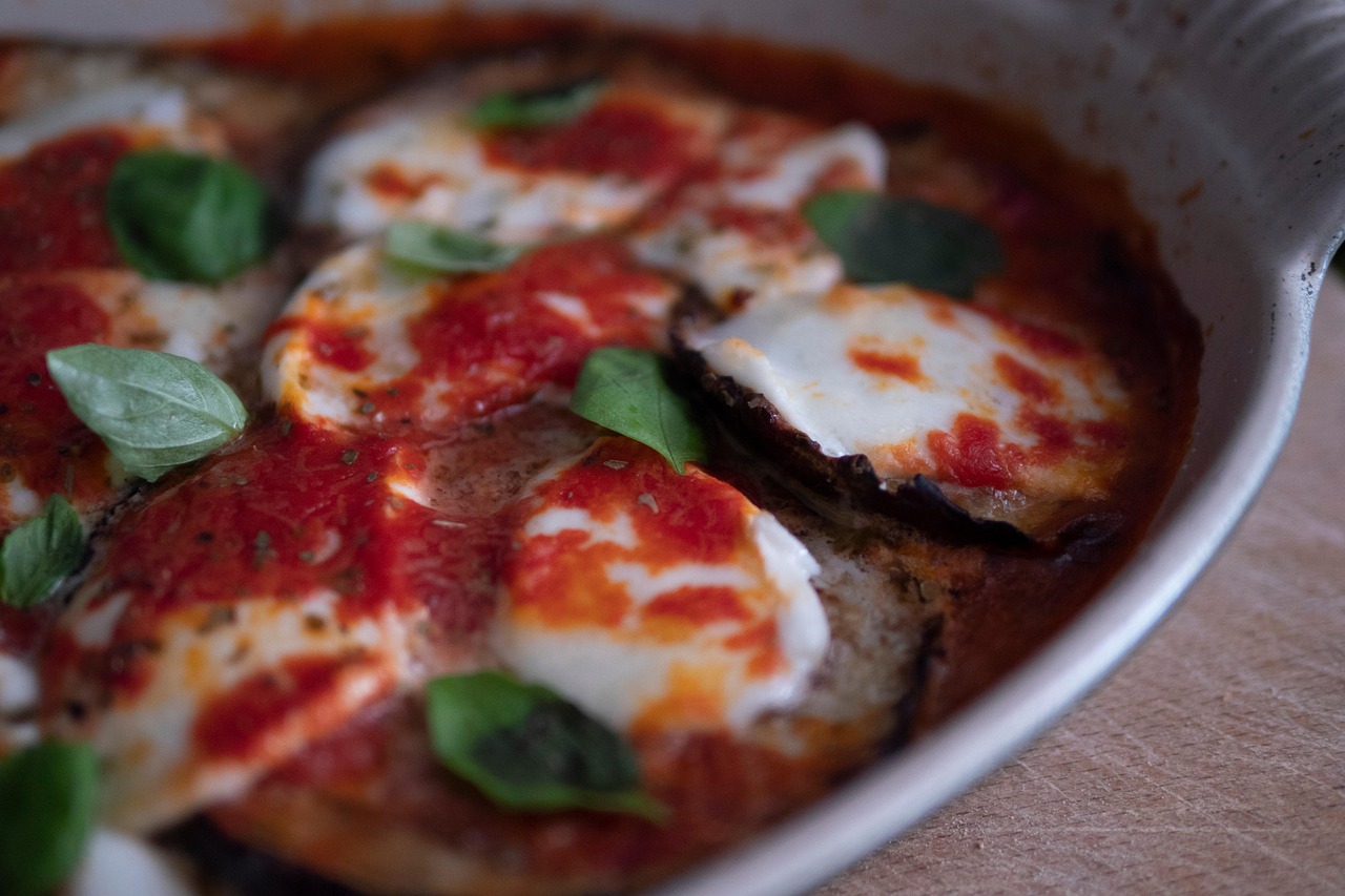 Melanzane alla parmigiana appena sfornate, con strati di formaggio fuso e salsa di pomodoro.