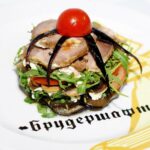 Melanzane a funghetto cucinate in padella, con pomodorini e basilico fresco.